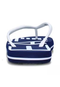 Ciabatte in gomma blu con cinturino bianco testurizzato, caratterizzate da un grande logo bianco sulla soletta e una suola bianca a contrasto.