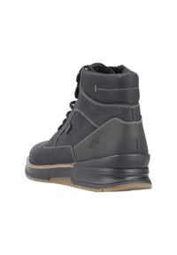 Bottine noire en cuir avec une surface texturée, des coutures blanches contrastantes et une semelle en caoutchouc durable. Lacets pour un maintien sécurisé et logo de la marque.
