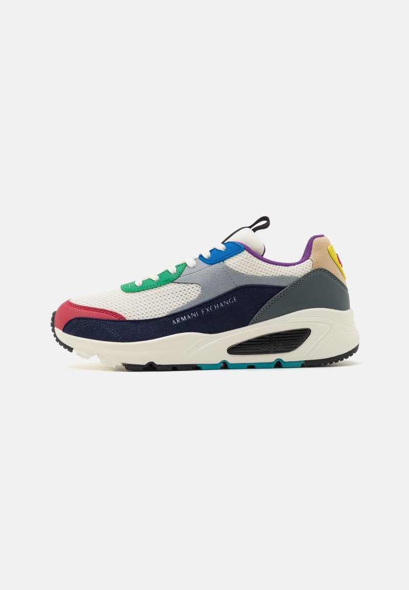 Zapatillas deportivas que combinan materiales como malla y ante, en blanco, azul marino, rojo, verde y púrpura, con detalles texturizados y el logotipo.