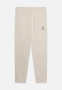 Pantalones de chándal gris claro con cintura ajustable por cordón, presentan un pequeño logo negro de Jumpman cerca del muslo izquierdo. Material de algodón suave y texturizado.