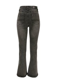 Jeans negros acampanados de talle alto, hechos de mezclilla, con dos bolsillos traseros y dobladillo limpio. La tela tiene una textura sutil.