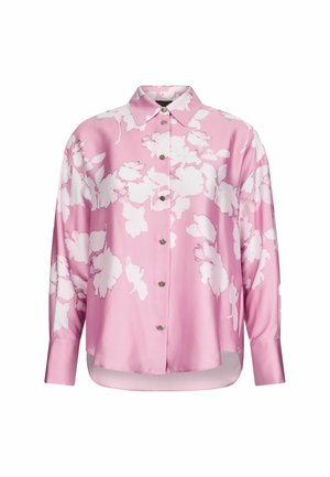 Blouse en satin rose avec un motif floral blanc, col, manches longues et un bouton devant avec un ourlet légèrement arrondi.