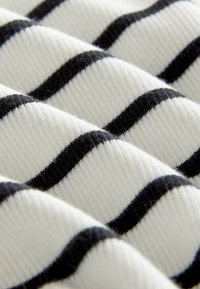 Black and white striped fabric with a ribbed texture, featuring alternating thick and thin stripes on a soft, woven base.