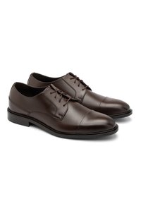 Scarpe eleganti in pelle marrone con una finitura liscia, punta tonda, chiusura con lacci e un tacco basso e piatto. I dettagli delle cuciture aggiungono un design sottile.