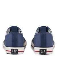 Zapatos slip-on de lona navy con suelas de goma blanca y acentos rojos. Presentan una placa de logo en el talón y una parte superior texturada para mayor agarre.