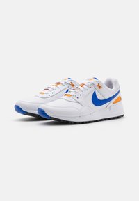 Bílé tenisky Nike s modrými akcenty a oranžovým detailem. Obsahují šňůrky a texturované černé gumové podešve. Hladký kožený svršek, polstrovaný límec.