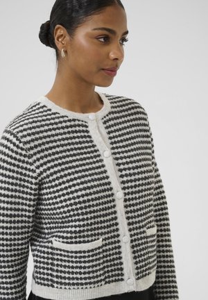 Kootud mustvalge triibulise mustriga kardigan, ümara kaelusega, eest nööbitav ja kahe esitaskuga. Pehme, tekstuuriga kangas.