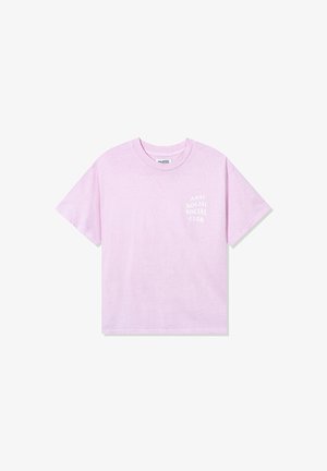 Krótki rękaw t-shirt w pastelowym różowym kolorze z białym napisem "ANTI SOCIAL SOCIAL CLUB" na lewej piersi, prezentowany na białym tle.