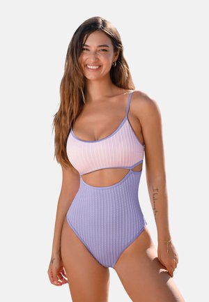 Ribbed one-piece swimsuit with pink and lavender sections, cut-out sides, thin straps, and a high-cut leg. Smooth texture, modern design.
