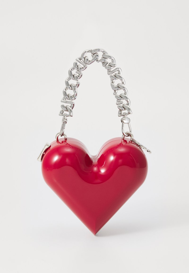 Κόκκινη τσάντα χρώματος καρδιάς από γυαλιστερό υλικό με ασημένια αλυσίδα και κούμπωμα. Λείο υλικό με στρογγυλεμένες άκρες.