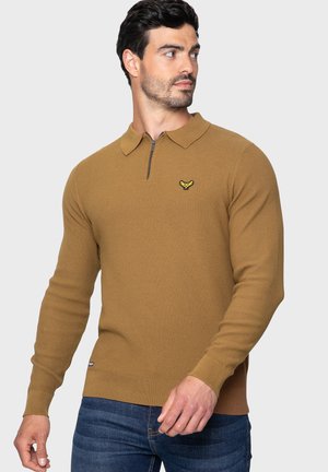 Hnědý pletený pulover s límcem na zip, se malým žlutým logem na hrudi. Hribované manžety a spodní okraj, strukturovaný vzor po celém povrchu.