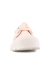 Baskets en toile rose clair avec une semelle en caoutchouc blanc, dotées d'un système de laçage, d'œillets en métal et d'une semelle texturée pour une meilleure adhérence.