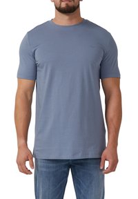 Lichtblauw t-shirt met korte mouwen, gemaakt van zachte stof en met een ronde halslijn. Bevat een klein logo-detail op de borst. Draagt met denim jeans.