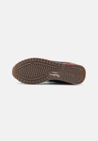 Multicolor sneaker sole featuring a textured, rubber material with a zigzag pattern, logo imprint, and horizontal lines for grip.