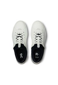 Sneakers bianchi in pelle con profilo basso, dotati di rivestimento in rete nera e lacci, punta con perforazioni e branding discreto sulle sole interne.