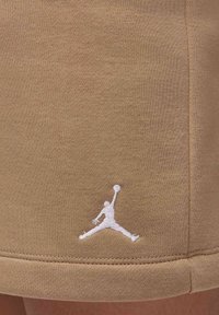 Khaki sportovní šortky vyrobené z pružného bavlněného materiálu. Mají vyšívané bílé logo Jumpman a standardně zakončené lemy.
