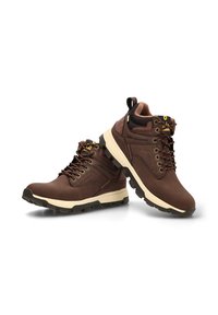 Botas de senderismo de cuero marrón con un acolchado en el tobillo, entresuela blanca, suela de goma negra y acentos amarillos en los cordones y la lengüeta.