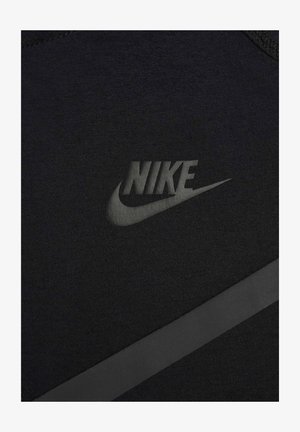 Black athletic fabric featuring a matte Nike logo and a textured strip, showcasing a minimalistic design with a smooth surface.