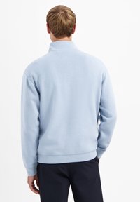 Lichtblauwe fleece pullover met een hoge kraag, lange mouwen en een effen textuur. Bevat een geribde zoom en manchetten.