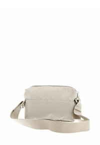 Sac bandoulière en tissu beige avec fermeture éclair, sangle ajustable et surface texturée, présentant un design rectangulaire simple sans marque visible.