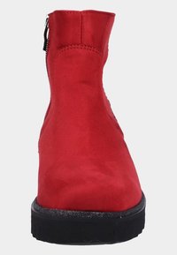 Röda mocka ankelskor med en platt svart gummisula, med en sidodragkedja och en smäcker, strömlinjeformad design. Slät yta, inga synliga mönster.