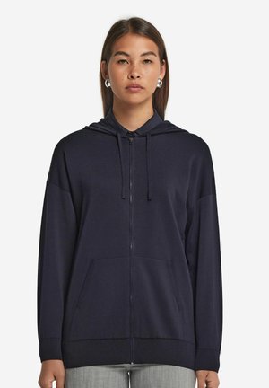 Marinefarbener Reißverschluss-Hoodie mit einer Fronttasche, Kapuze mit Zugbändern, Rippstrickbündchen und relaxter Passform. Weicher Stoff mit glatter Textur.