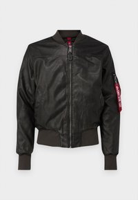 Dark brown leather bomber jacket with ribbed cuffs and hem, front zipper, two side pockets, and a red tag on the left sleeve.