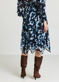 Abito svasato e asimmetrico in trasparente blu e nero con stampa animale, dotato di maniche lunghe a balze e una texture liscia, abbinato a stivali marroni morbidi.