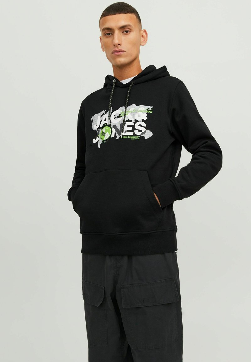 Crna dukserica od pamuka s prednjim džepom u stilu kengura. Ima bijelu i zelenu grafiku loga "Jack & Jones". S kapuljačom koja se podešava uz pomoć vrpce.