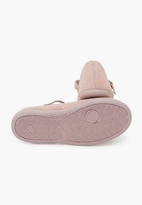 Zapato de ante rosa con una textura suave, parte trasera cerrada, correa ajustable y suela de goma estampada con un diseño de banda distintivo.