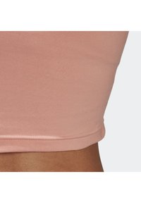Růžový vypasovaný crop top vyrobený z pružné směsi bavlny, s hladkou texturou a jednoduchým lemem bez dalších kovových prvků nebo dekorací.
