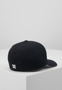 Gorra de béisbol negra hecha de tejido de algodón, con una visera curvada y un logo bordado en la parte posterior. Diseño simple sin adornos.