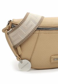 Borsa a tracolla in pelle beige con superficie testurizzata, zip argentata e tracolla in tessuto con motivo e charm del logo.