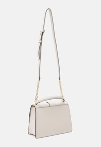 Borsa a mano in pelle crema con dettagli in catena dorata, manico superiore e tracolla regolabile su sfondo bianco.