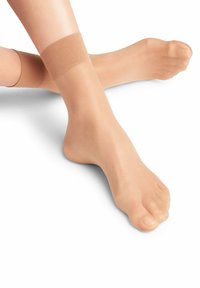 Durchsichtige, hautfarbene Strumpfhosen mit einer glatten, strukturierten Oberfläche; weicher, elastischer Bund am Knöchel. Geeignet für warme Wetterbedingungen.