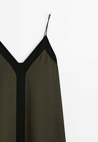 Robe sans manches en V, de couleur vert olive et noir, présentant une texture douce, des bretelles fines réglables, et un design de bloc de couleur contrasté.