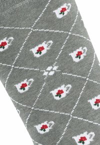 Graue Knöchelsocke mit einem wiederholten Muster aus weißen Teekannen mit roten Rosen, getrennt durch weiße Rautenformen und Akzenten. Weiche Textur.