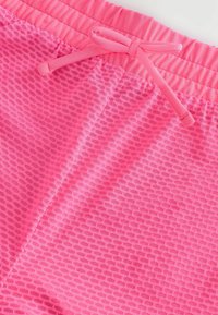 Roze mesh shorts met een elastische tailleband en trekkoord. Kenmerkend is het gestructureerde patroon en de gladde stof, geschikt voor sport of casual draag.