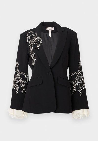 Μαύρο εφαρμοστό σακάκι με λευκή κεντητή διακόσμηση από λουλούδια και φιόγκους στους ώμους και τα μανίκια, με ένα κουμπί και λευκές δαντελένιες μανσέτες.