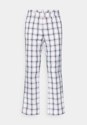 Juodos ir baltos langinės kelnės su platėjančiu siluetu, pasižyminčios mygtukų uždarymu ir tekstūruota medžiaga. Raštas apima kaitaliuojančias plonas ir storas juostas.