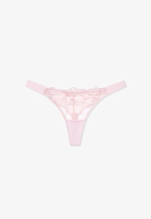 String en dentelle rose avec motif floral, présentant un dos transparent et des bretelles élastiques douces, mettant en valeur des accents féminins et une texture délicate.