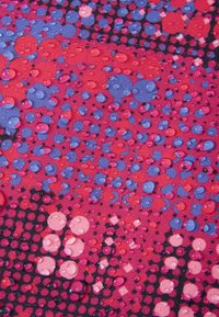 Tkanina z żywym wzorem w odcieniach różu, niebieskiego i fioletu, z kroplami wody na teksturowanej powierzchni, nadającymi jej połysk.