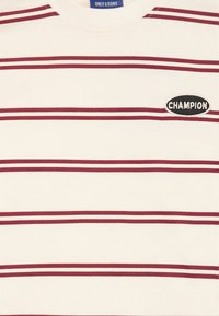 White striped t-shirt with burgundy horizontal stripes, round neckline, and an embroidered "Champion" logo on the left side. Cotton material.