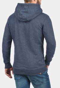 Sudadera azul marino hecha de una suave mezcla de algodón, con un bolsillo tipo canguro, puños acanalados y capucha con cordón y un acabado texturizado.