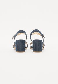 Denim plattform sandaler med en chunky hæl, som har åben bag, justerbar ankelrem og metalliske detaljer i remmen.