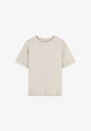 Helle beige Baumwoll-T-Shirt mit kurzen Ärmeln, rundem Ausschnitt und umgeschlagenen Ärmelsäumen. Sanfte Textur, keine sichtbaren Muster oder Akzente.