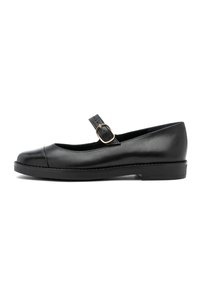 Zapato negro de estilo Mary Jane en piel con una punta brillante, correa ajustable y hebilla dorada. Suela plana con sutiles detalles de costura.