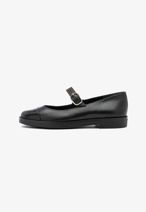 Zapato negro de estilo Mary Jane en piel con una punta brillante, correa ajustable y hebilla dorada. Suela plana con sutiles detalles de costura.
