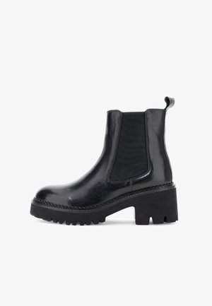 Czarne skórzane botki Chelsea z masywną podeszwą z bieżnikiem, elastycznym panelem bocznym, uchwytem i słupkowym obcasem na białym tle.