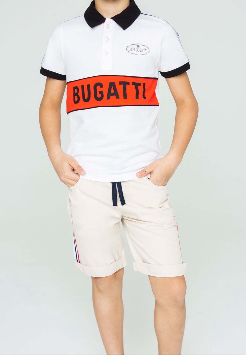 Polo shirt blanc avec col noir, bande "BUGATTI" rouge et noire, associé à un short beige avec des revers repliés et des accents rayés.